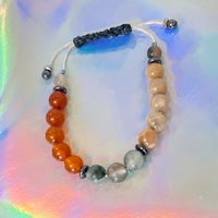 a bracelet with orange, brown, and black beads